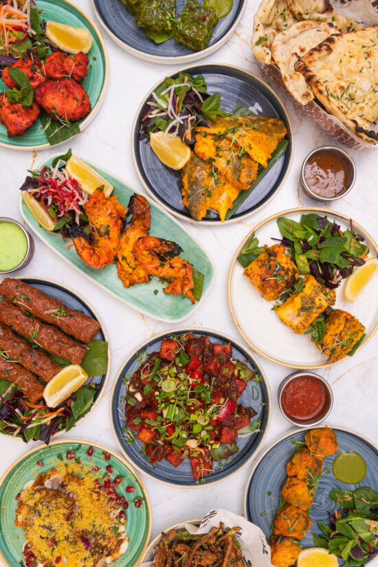 A vibrant spread of assorted Indian dishes at Bhageecha, featuring grilled meats, kebabs, naan bread, colorful salads, and fresh chutneys—perfect for weddings at Bhageecha or anyone seeking an authentic Indian restaurant near me. | Indian Restaurant Elstree Borehamwood